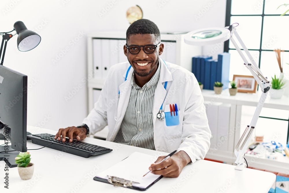 Young african american man wearing doctor uniform working at clinic