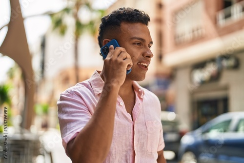 Young latin man smiling confident talking on the smartphone at street