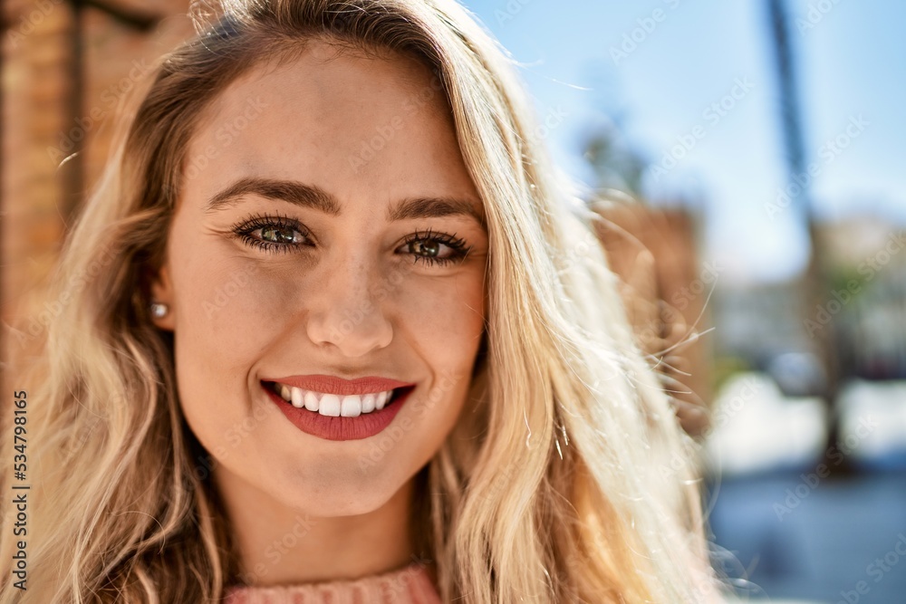 Young blonde woman smiling at the city Young blonde woman smiling at the city