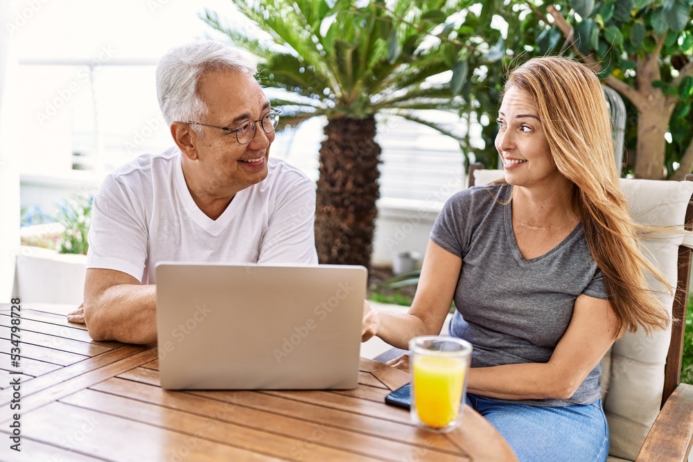 Middle age hispanic couple using laptop at the terrace. Middle age hispanic couple using laptop at the terrace.