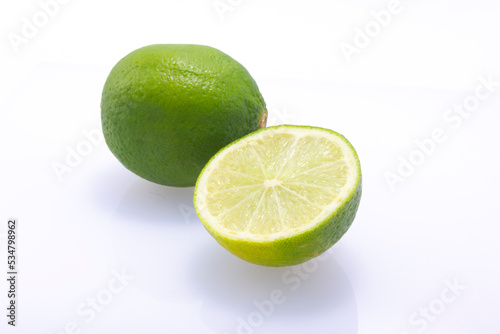 Green limes, cut in half and whole, isolated on white background.