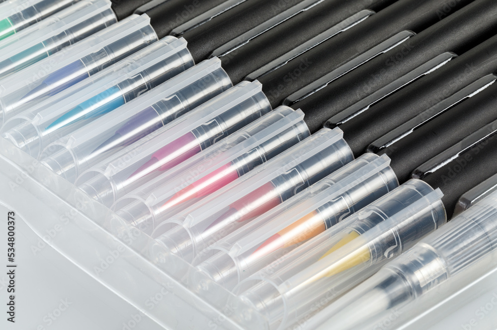 A set of new multi-colored brushes on a white background. Close-up. A set of new multi-colored brushes on a white background. Close-up.