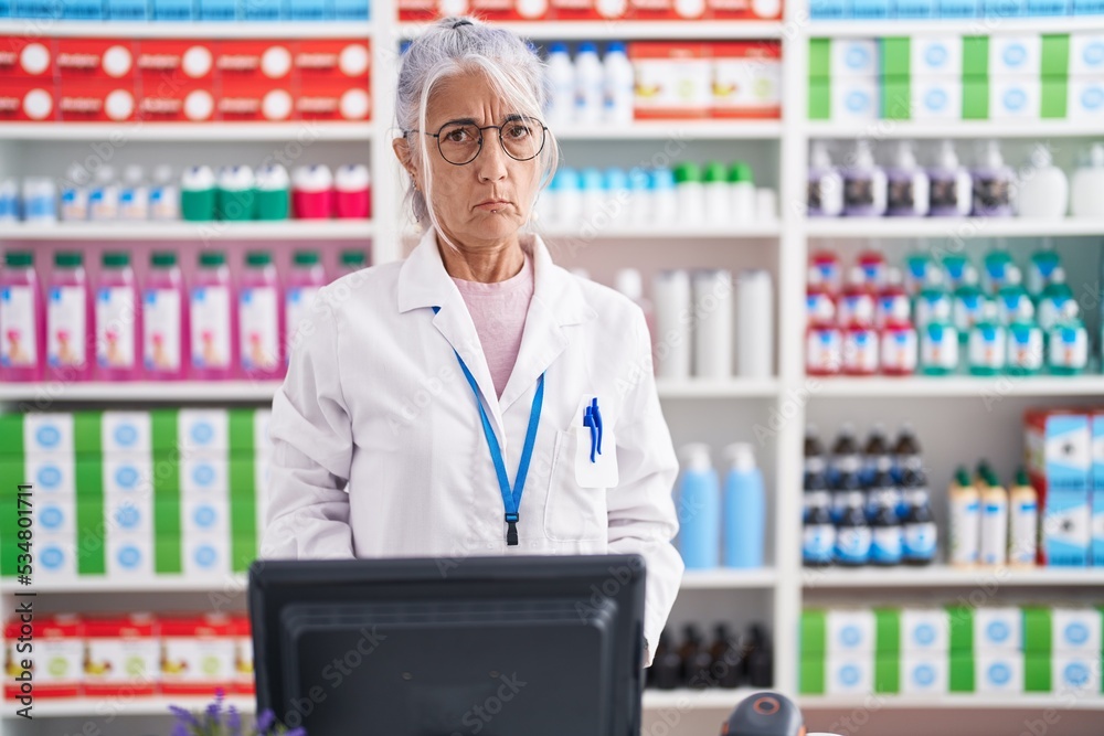 Middle age woman with tattoos working at pharmacy drugstore skeptic and nervous, frowning upset because of problem. negative person. Middle age woman with tattoos working at pharmacy drugstore skeptic and nervous, frowning upset because of problem. negative person.
