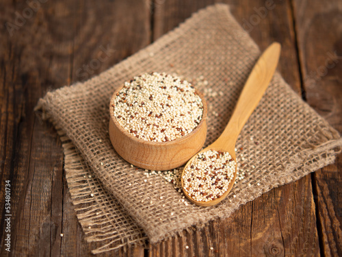 mixed raw quinoa in bowls on a wooden background. Healthy and gluten free food. photo
