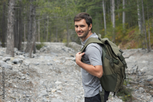 Caucasian man walking in the forest wearing a tourist backpack