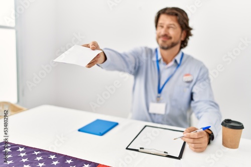 Middle age caucasian man smiling confident holding vote at electoral college