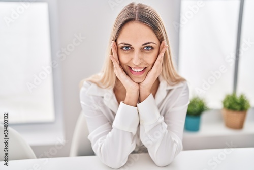 Young woman smiling confident sitting on table at home © Krakenimages.com