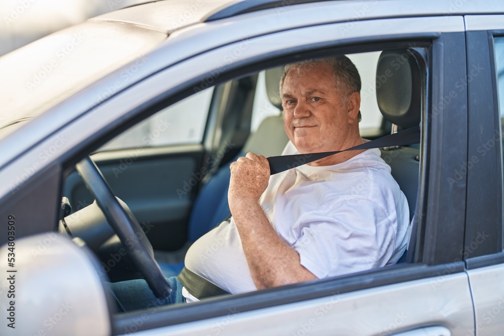 Middle age grey-haired man smiling confident wearing car belt at street