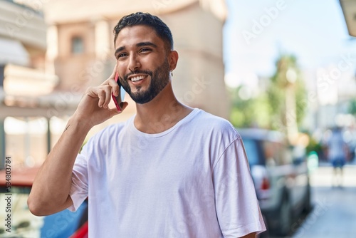 Young arab man smiling confident talking on the smartphone at street