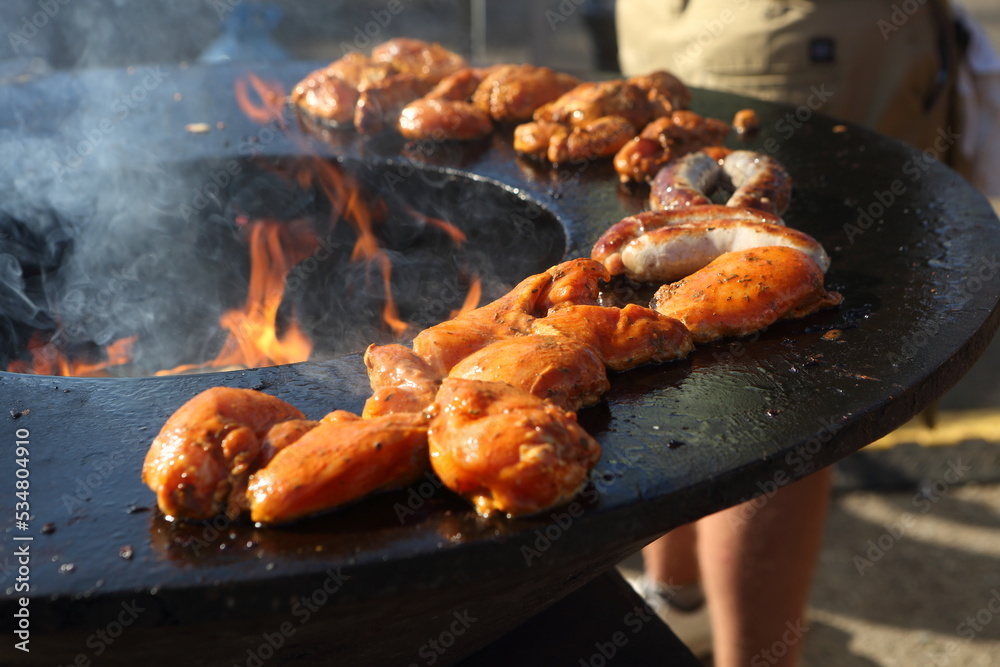 Chicken skewers being cooked outside