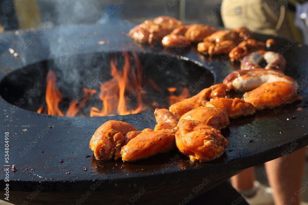 Chicken skewers being cooked outside