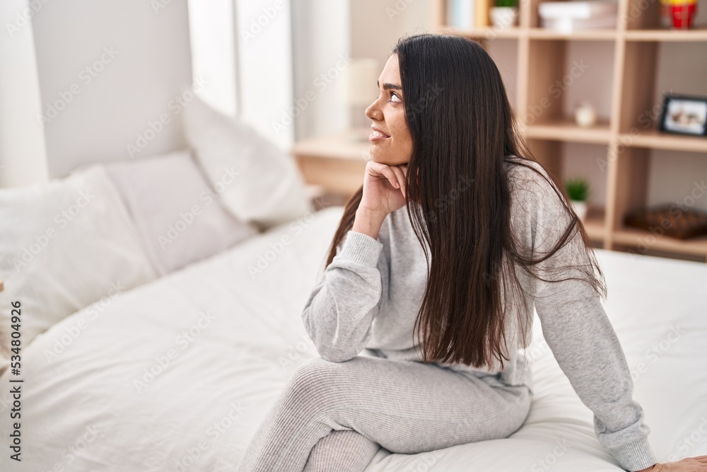 Young hispanic woman smiling confident sitting on bed at bedroom Young hispanic woman smiling confident sitting on bed at bedroom