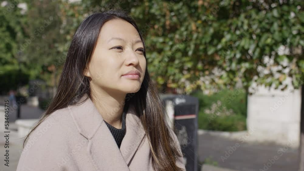 Attractive young woman walking through a city park in the daytime, in slow motion Attractive young woman walking through a city park in the daytime, in slow motion