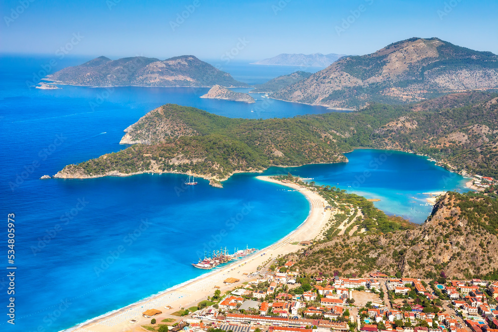 Summer sunny day in blue lagoon surrouded by mountains, Oludeniz (Turkey). Amaizing view from mountain to turistic city Oludeniz. Beautiful view on summer sea with ships.