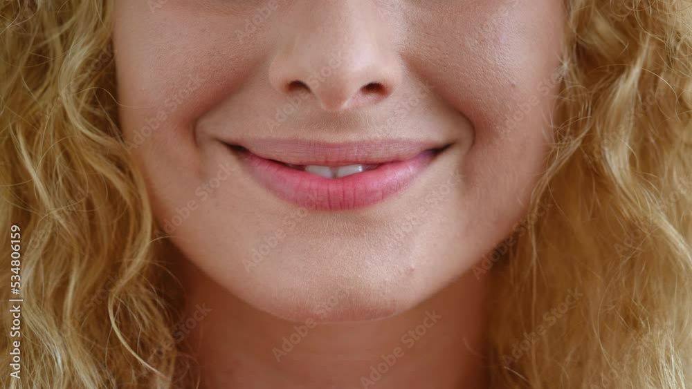 Selective focus on the lips of a beautiful redhead young Caucasian woman, smiling a cheerful toothy smile standing forward to camera. White teeth, oral care, dental hygiene, teeth whitening concept Selective focus on the lips of a beautiful redhead young Caucasian woman, smiling a cheerful toothy smile standing forward to camera. White teeth, oral care, dental hygiene, teeth whitening concept