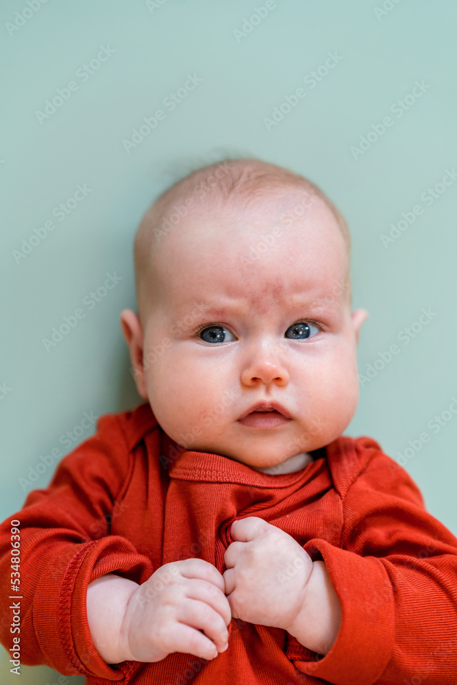 Portrait of a cute funny Caucasian baby on a green background. Place for text, copy space Portrait of a cute funny Caucasian baby on a green background. Place for text, copy space