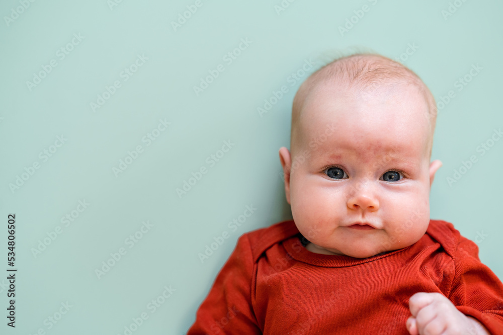 Portrait of a cute funny Caucasian baby on a green background. Place for text, copy space Portrait of a cute funny Caucasian baby on a green background. Place for text, copy space