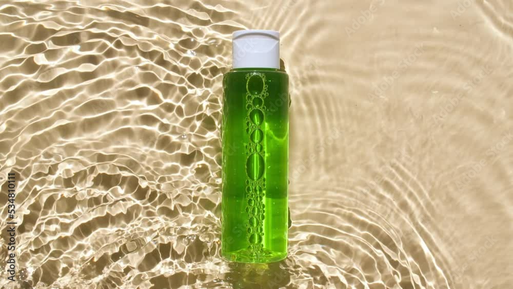 Cosmetic bottle, vial for oil, liquid, collagen serum on water surface with drops. Women's cosmetics skincare. Sample of layout of package beauty product. High quality 4k footage Cosmetic bottle, vial for oil, liquid, collagen serum on water surface with drops. Women's cosmetics skincare. Sample of layout of package beauty product. High quality 4k footage