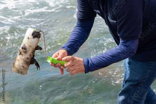 Cleaning agents extract oil from beach in the city. Using protective equipment.