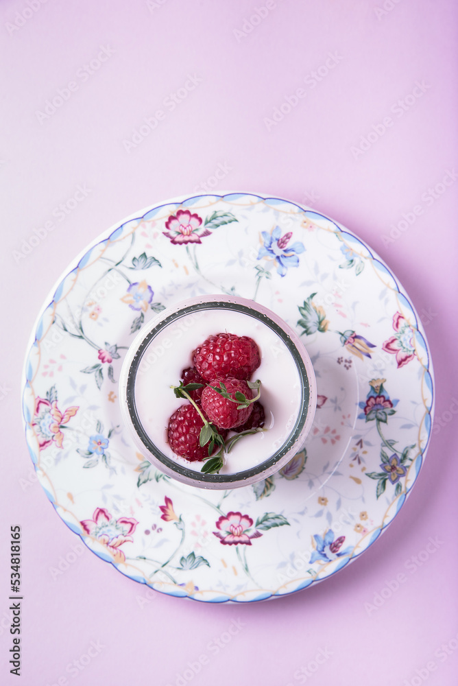 Milk yogurt with raspberries in a bowl on a pink background Milk yogurt with raspberries in a bowl on a pink background