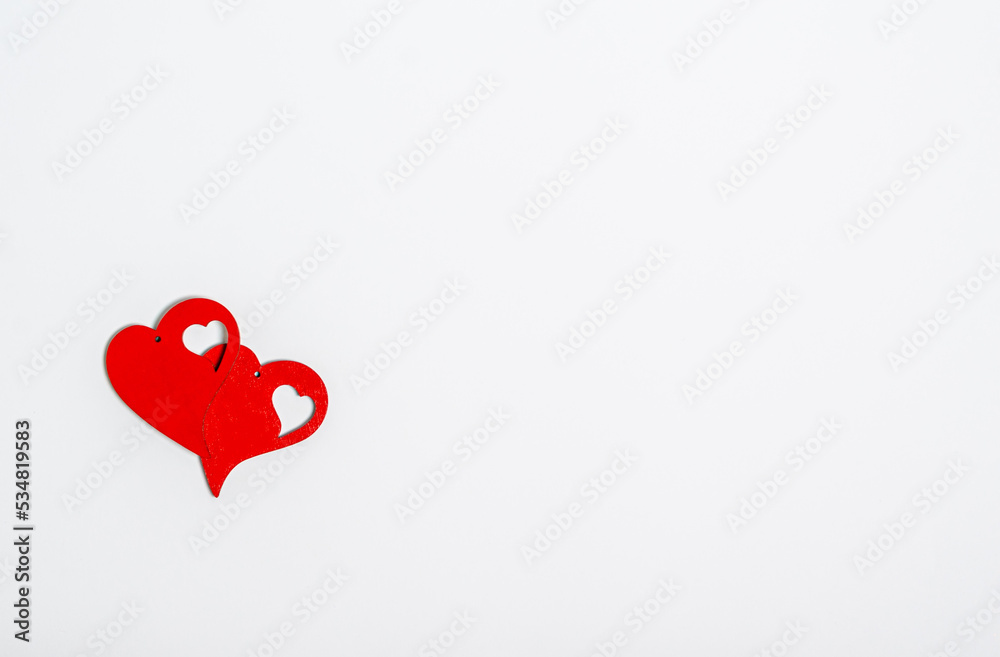 Two red wooden hearts on a white background with place for text Two red wooden hearts on a white background with place for text