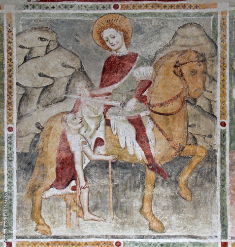 San Martino dona il mantello. Affresco nella chiesetta dei Santi Ippolito e Cassiano a Castel Tesino (Trentino) photo