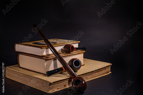 Cuadro en lienzo Tobacco pipes lying on the books