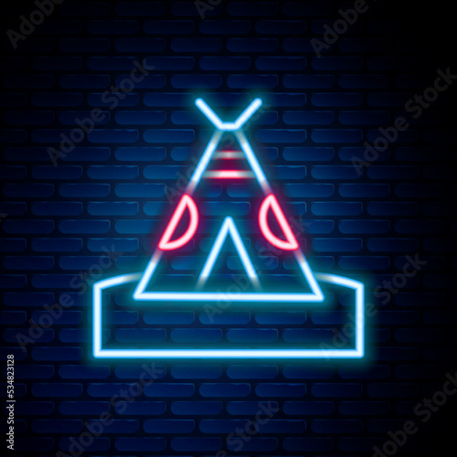 Glowing neon line Traditional indian teepee or wigwam icon isolated on brick wall background. Indian tent. Colorful outline concept. Vector