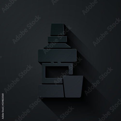 Paper cut Mouthwash plastic bottle and glass icon isolated on black background. Liquid for rinsing mouth. Oralcare equipment. Paper art style. Vector