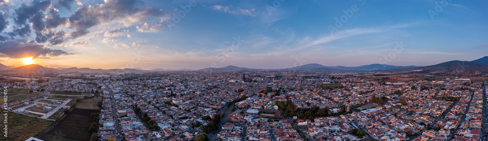 Aerial: spectacular sunset in the mountains and cityscape. Drone view