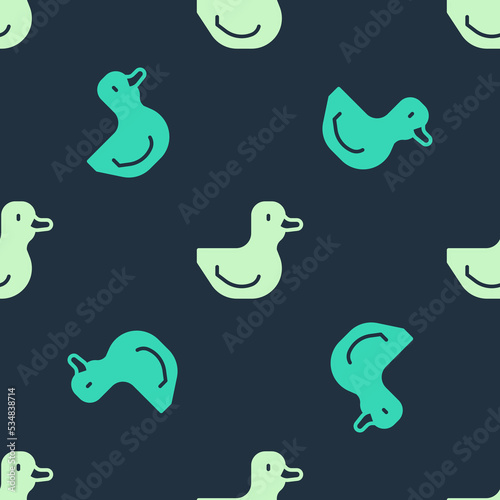 Green and beige Rubber duck icon isolated seamless pattern on blue background. Vector