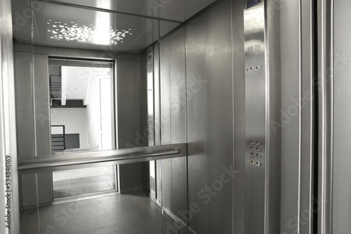 Open elevator`s cabin with big mirror indoors
