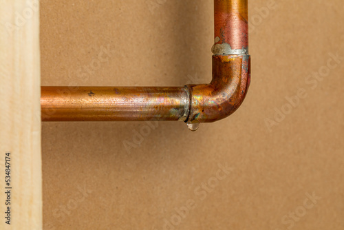 Photo Copper plumbing pipe leaking water inside wall