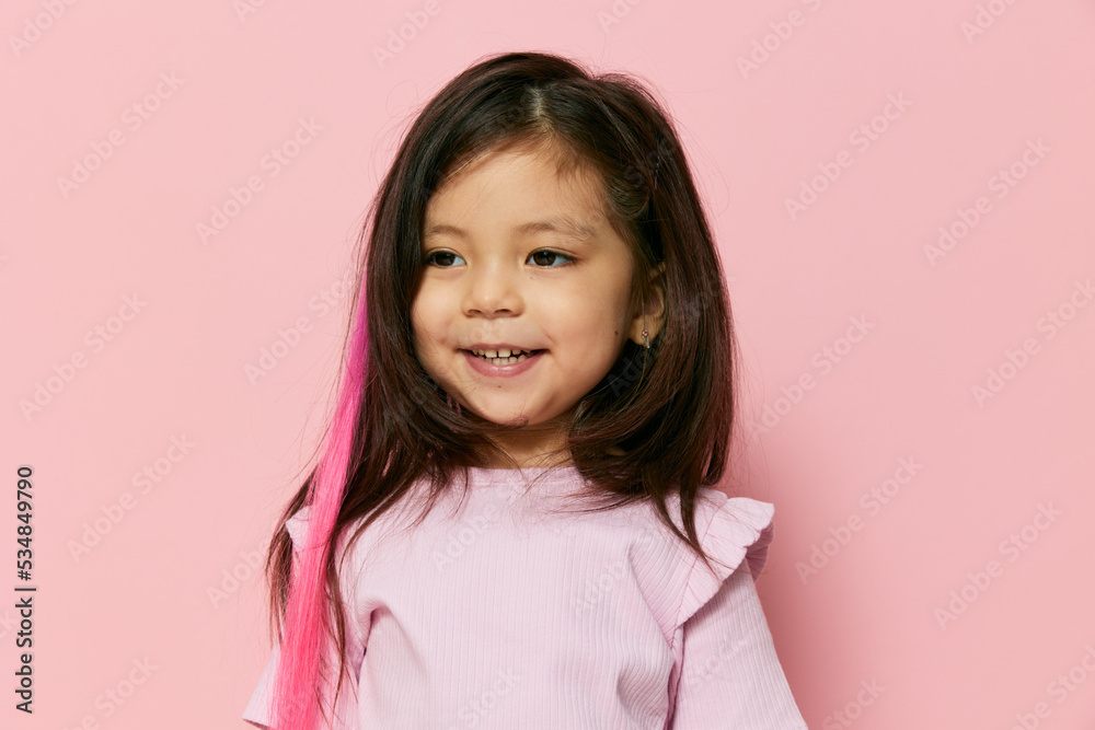 a cute beautiful little preschool girl is standing on a pink background in a pink T-shirt smiling from the top of her mouth with her eyes slightly closed a cute beautiful little preschool girl is standing on a pink background in a pink T-shirt smiling from the top of her mouth with her eyes slightly closed