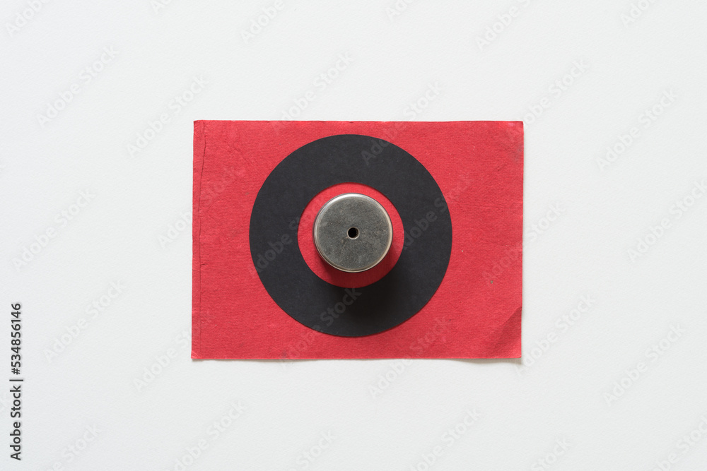 circular magnets inside a black paper ring on a red and white background circular magnets inside a black paper ring on a red and white background