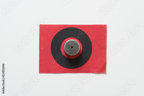 circular magnets inside a black paper ring on a red and white background