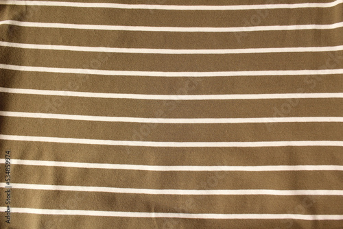 Green ocher crumpled fabric linen with white stripe for creative background. Copy space. Natural textile for wallpaper or design