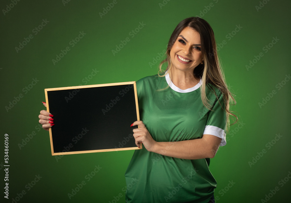 woman soccer fan cheering for her favorite club and team. world cup green background. Holding a blackboard. woman soccer fan cheering for her favorite club and team. world cup green background. Holding a blackboard.