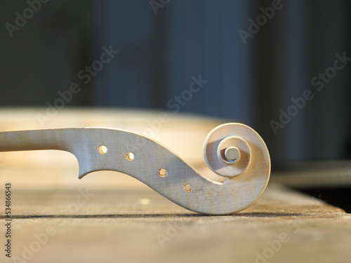 Fotografie raw blank violin scroll at maker desk