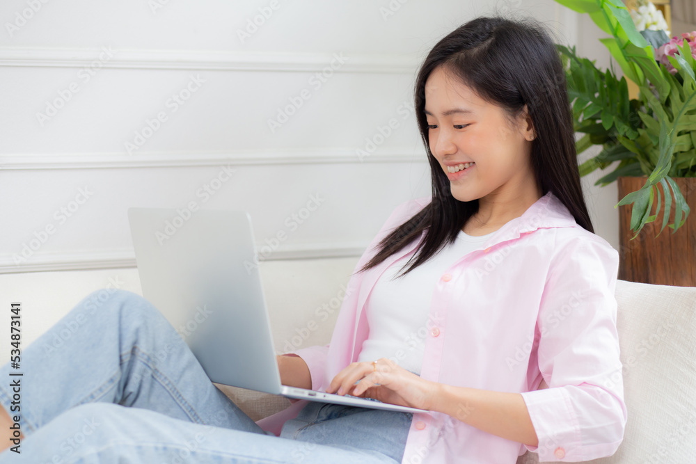 Young asian business woman work from home with laptop computer online to internet on sofa in living room, freelance girl using notebook sitting on couch with comfort and relax, lifestyles concept. Young asian business woman work from home with laptop computer online to internet on sofa in living room, freelance girl using notebook sitting on couch with comfort and relax, lifestyles concept.