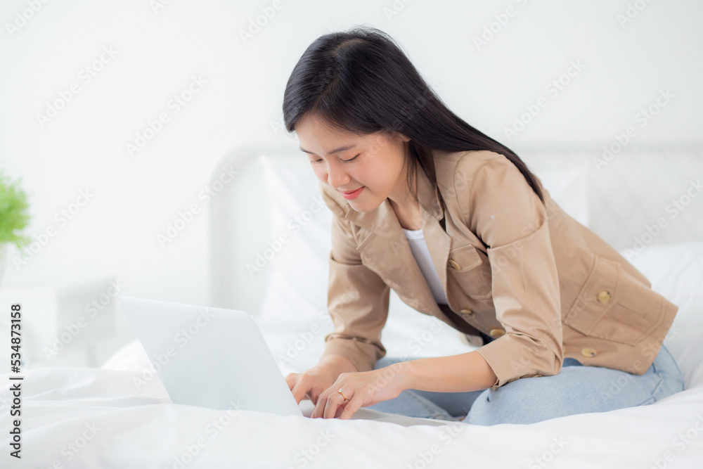 Beautiful young asian woman sitting on bed using laptop computer working from home in the bedroom, female is freelance using notebook online, one person, business and lifestyles concept. Beautiful young asian woman sitting on bed using laptop computer working from home in the bedroom, female is freelance using notebook online, one person, business and lifestyles concept.