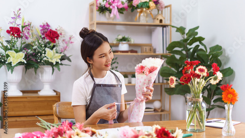 Florist concept  Female florist smile and holding colorful flower bouquet with paper and ribbon bow