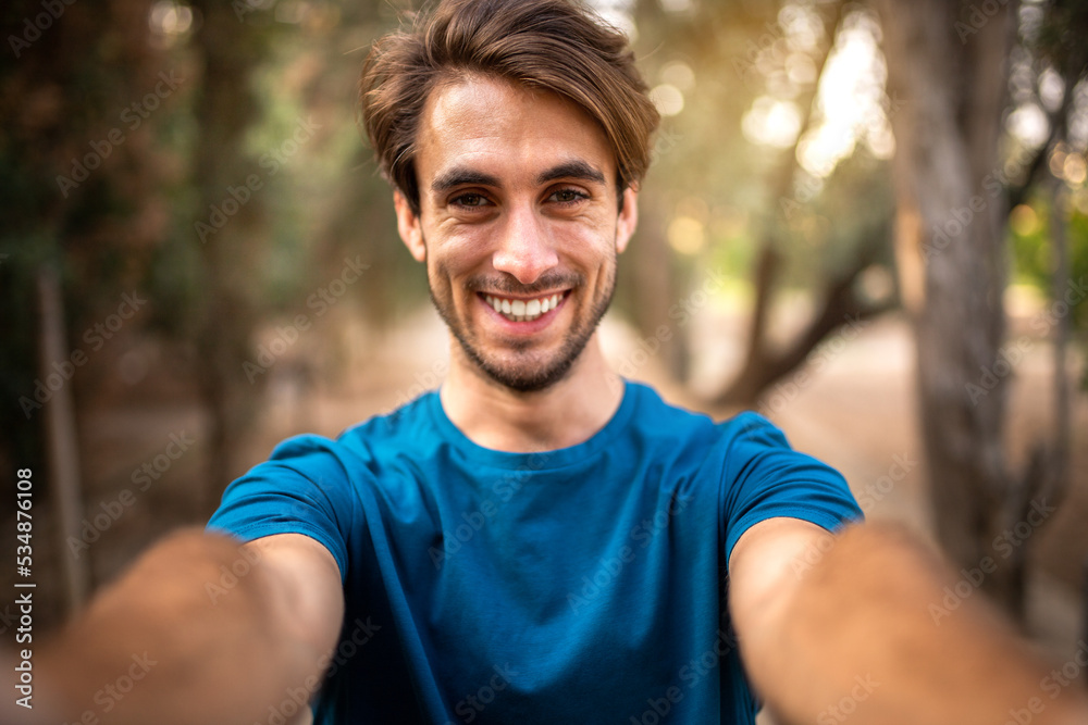 Young smiling caucasian man taking selfie in the forest looking at camera. Young smiling caucasian man taking selfie in the forest looking at camera.