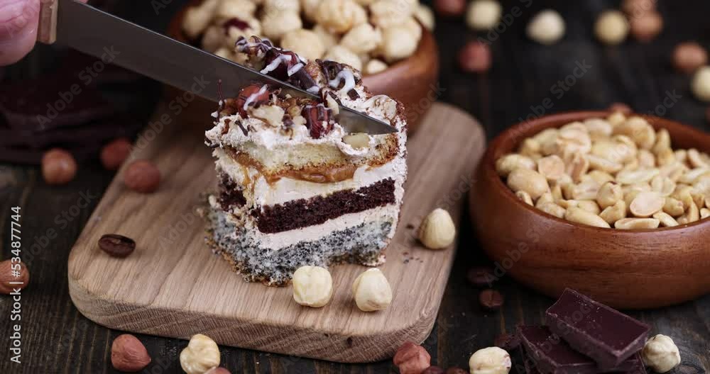 cut multi-layer cake with different layers, caramel, poppy seeds and cream layers of cake for dessert with nuts cut multi-layer cake with different layers, caramel, poppy seeds and cream layers of cake for dessert with nuts