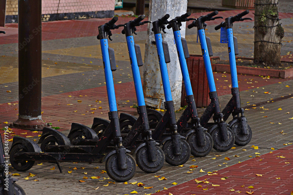 Group of scooters on autumn street.