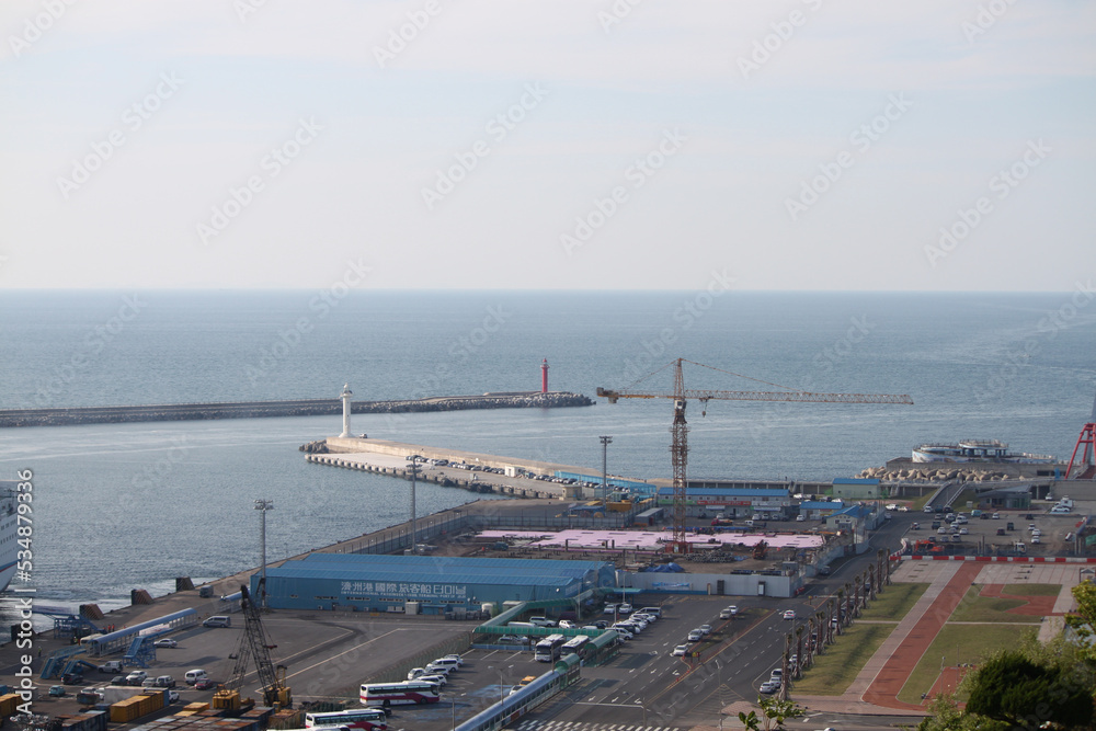 A view of the port where the passenger terminal construction is in full swing: breakwater, lighthouse, and crane for construction