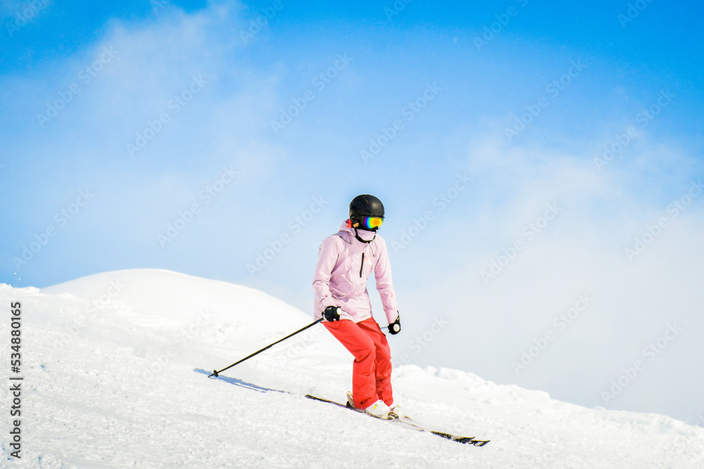 Young woman skier ski ride downhill in scenic caucasus mountains in fast freeze motion steep downhill solo