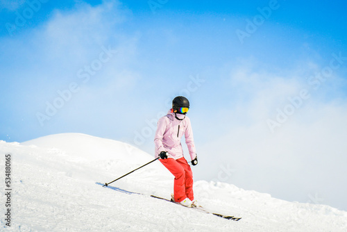 Obraz na plátně Young woman skier ski ride downhill in scenic caucasus mountains in fast freeze