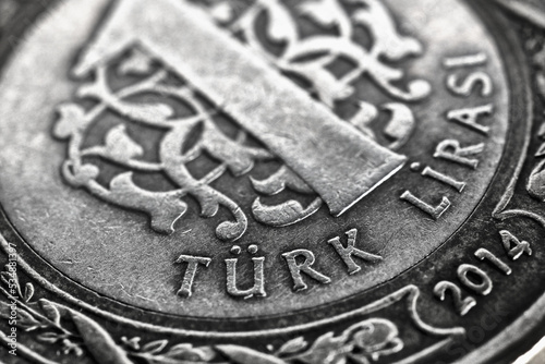 Translation: Turkish lira. Fragment of 1 lira coin close up. National currency of Turkey. Black and white illustration for news about economy or finance. Money and bank in Turkey. Macro photo