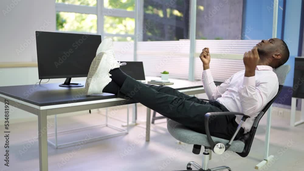 Side View Of Relaxed Young Businessman Sitting Feet Up Side View Of Relaxed Young Businessman Sitting Feet Up